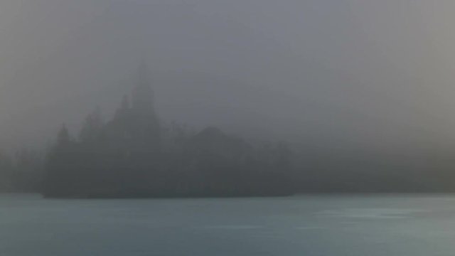 Bled Lake Island in the Fog in a Winter day with Iced Lake. HD 4K Time Lapse. Bled lake its castle and iconic island with church is a Slovenia iconic place with terme and hotel. Bled 5 February 2017.