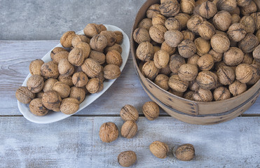 Walnut kernels and whole walnuts on the rustic grunge  table.