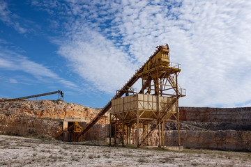 Fototapeta na wymiar Former stone quarry with abandoned crusher and conveyor machines. Apulia region, Italy.
