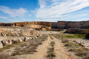 Fototapeta na wymiar Former stone quarry with abandoned crusher and conveyor machines. Apulia region, Italy.