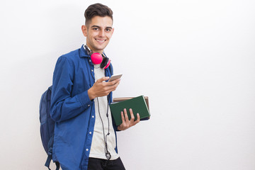 college adolescent student with books and mobile phone on wall background