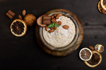 Oatmeal in bowl on wooden dark table 