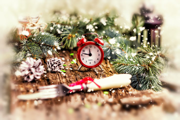 Fototapeta na wymiar Christmas concept. Alarm clock with spruce pine twigs cones and 