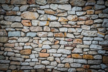Stone wall background of colorful stones with vignetted borders