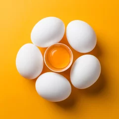 Poster White eggs and egg yolk on the yellow background. topview, square © masanyanka