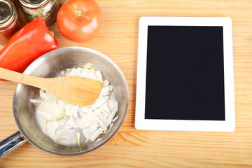 Vegetables and seasonings with a digital tablet.