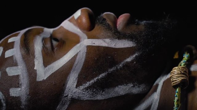 The face of the Papuan in white patterns that comes to life in the darkness