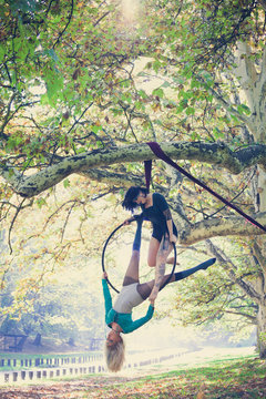 two young women aerial hoop  dance in forest