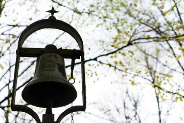 Obraz premium metal iron bell in park historic antique
