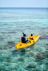 Family kayaking at tropical ocean