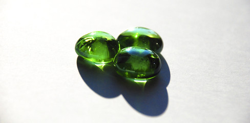 three green round crystals against afternoon sun