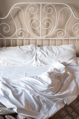 Fototapeta na wymiar Crumpled white bedclothes. Background. Vintage bed.