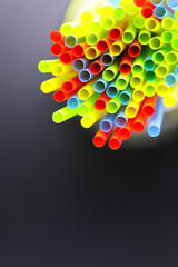 colored plastic cocktail tubes standing in a glass