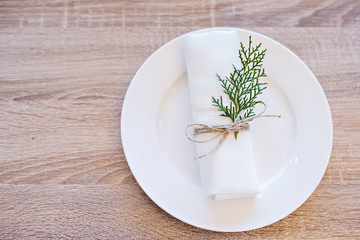New Year and Christmas 2018. Christmas plate on the table with a napkin and spruce branch.