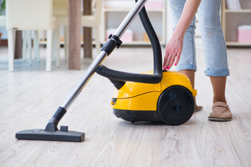 Woman doing cleaning at home with vacuum cleaner