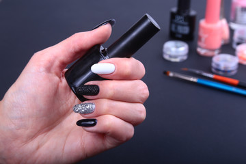 Black, white Nail art manicure. Holiday style bright Manicure with sparkles. Bottle of Nail Polish. Beauty hands. Stylish Nails, Nail Polish