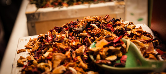 Naklejka na ściany i meble Herbal tea infusion with orange peels and hibiscus for sale at Christmas market in Paris. Selective focus on the top of the heap.