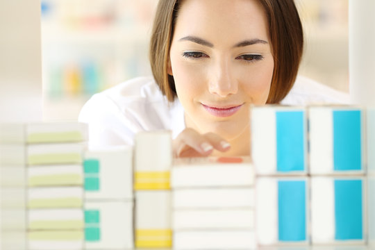 Relaxed pharmacist searching medicines in a pharmacy