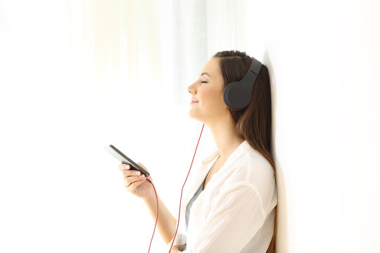 Woman relaxing listening to music isolated at side