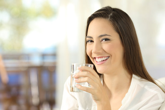 Happy woman holding a glass of water