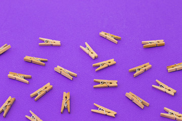 Set of wooden clothespins on bright violet background