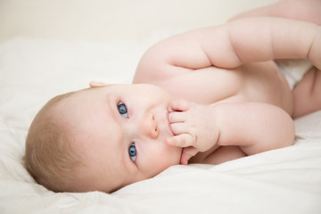 little baby girl with blue eyes  sucking fingers drooling