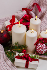White glowing advent candles with christmas decorations