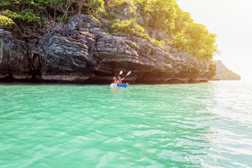Two women are mother and daughter. Travel by boat with a kayak under sunlight at summer around Ko...