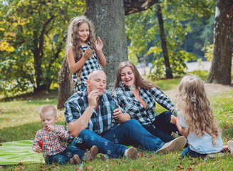 Fototapeta premium Young family with cheerful children in the park
