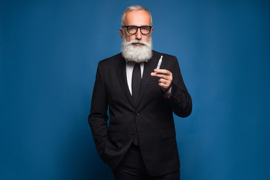Bearded business man smoking electronic cigarette in the suit. New technology of healthy smoking of electronic vaping cigarette.