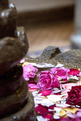 Rose petals & flowers float in a courtyard fountain- shallow depth of field