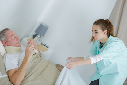 nurse putting a blanket on the patient