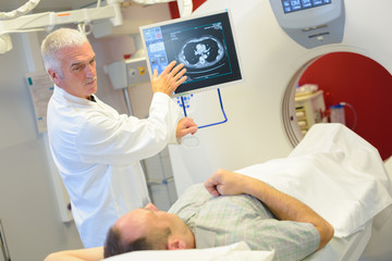 Man having scan, doctor discussing results - obrazy, fototapety, plakaty