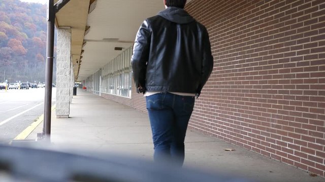 Young Greaser Millennial walking outside shopping plaza in Autumn ALT