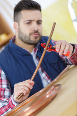 young plumber cutting copper pipe