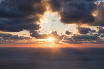 Obraz premium Beautiful colorful sunset at the sea with dramatic clouds and sun shining. Beauty world natural outdoors travel background