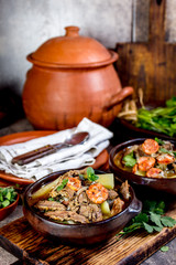 Chilean Ajiaco. Latin American food. Ajiaco - traditional chilean soup with grilled meat, onion and potato served in clay plates