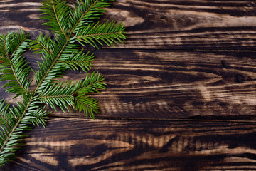Christmas fir tree on black wooden background.