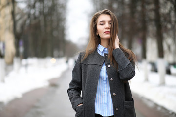 Young adult girl in coat on the street