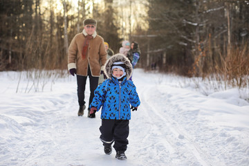 Fototapeta na wymiar Kid running in winter park and have fun with family