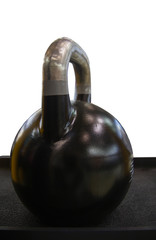 Obraz na płótnie Canvas Sport equipment in gym. weight black kettlebell stand on the black shelf in the gym white background