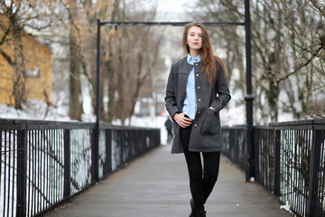 Obraz premium Young adult girl in coat on the street