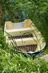Naklejka premium old plastic boat forgotten in the grass