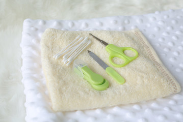 Collection of items for newborn babies on the towel on white fur.