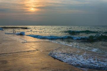 Beach sunset above the sea. Sunset at twilight with waves and sun reflection over the water....