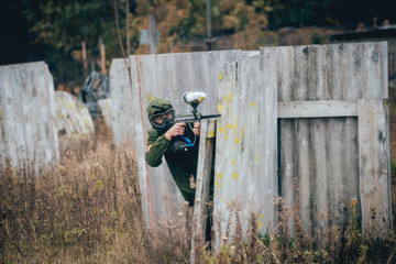 Man with gun playing at paintball. Outdoors