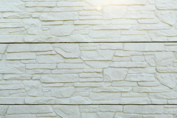 The wall is covered with decorative panels made of artificial stone is painted white closeup
