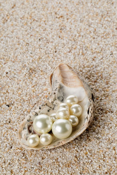 Multiple pearls in oyster sea shell on sand