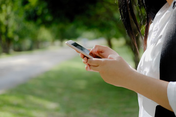 Asian woman using smartphone in park