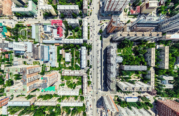 Fototapeta premium Aerial city view with crossroads and roads, houses, buildings, parks and parking lots, bridges. Helicopter drone shot. Wide Panoramic image.